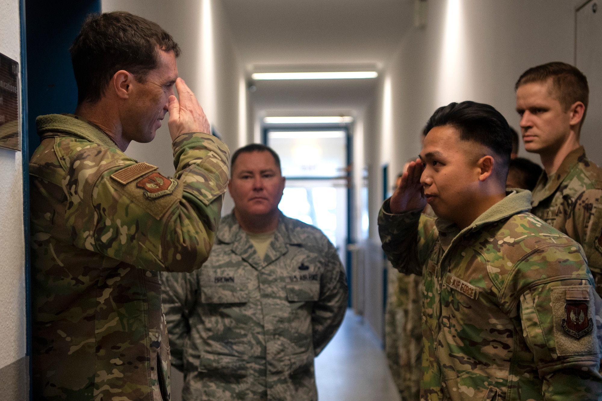 U.S. Air Force Col. David Epperson, 52nd Fighter Wing commander, left, and Senior Airman John Sierra, 702nd Munitions Support Squadron radio frequency transmission system technician, front right, render a salute at Buechel Air Base, Germany, Dec. 5, 2019, during a commander immersion tour. Epperson presented a coin to Sierra and several other Airmen in the squadron for their outstanding performance. (U.S. Air Force photo by Airman 1st Class Valerie Seelye)