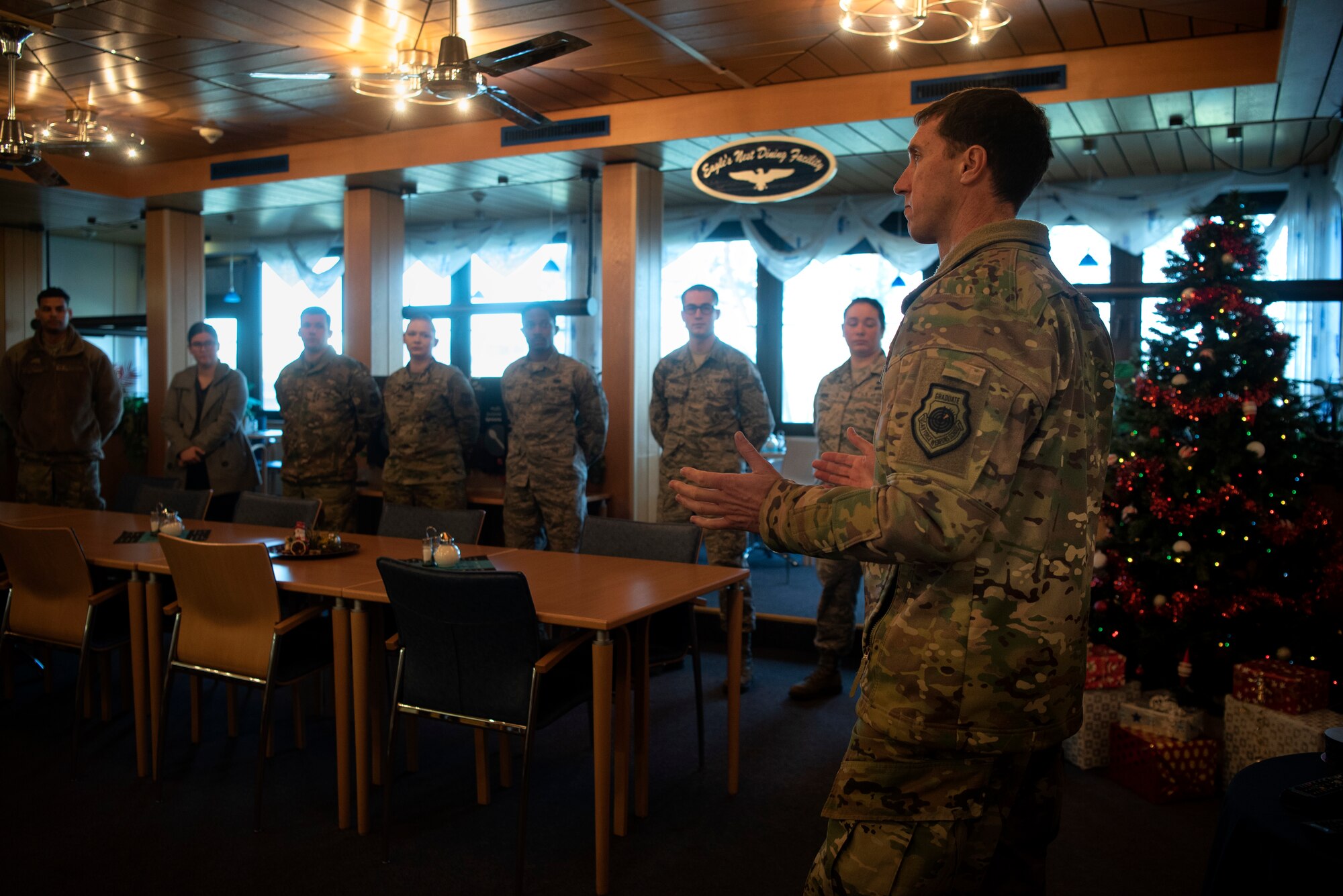 U.S. Air Force Col. David Epperson, 52nd Fighter Wing commander, right, speaks with Airmen from the 702nd Munitions Support Squadron in the dining facility at Buechel Air Base, Germany, Dec. 5, 2019. Epperson toured the 702nd MUNSS to gain a better understanding of the unit's capabilities and to meet the geographically separated unit's Airmen. (U.S. Air Force photo by Airman 1st Class Valerie Seelye)