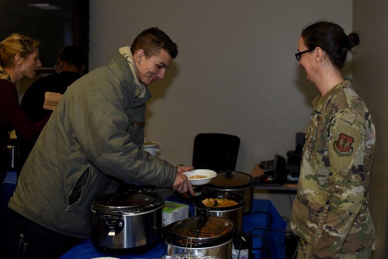 A Liberty Wing Airman prepares a bowl of chili at the Mid-Shift Chili Fest at Royal Air Force Lakenheath, England, Dec. 5, 2019. The Chili Fest was the first iteration hosted by various helping agencies around the Liberty Wing, as a part of the RAF Lakenheath Community Action Team. (U.S. Air Force photo by Airman 1st Class Rhonda Smith)