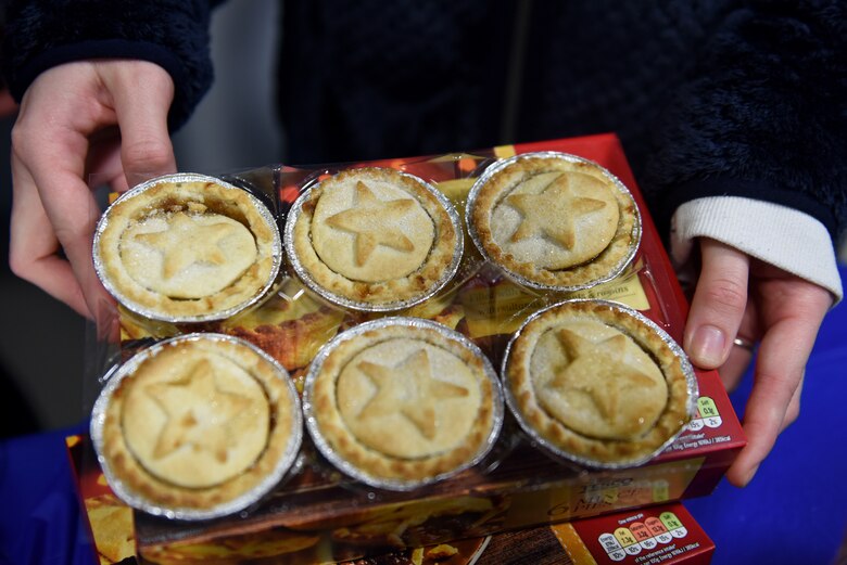 A volunteer sets out desert at the first ever Mid-Shift Chili Fest at Royal Air Force Lakenheath, England, Dec. 5, 2019. The event was held for Airmen who would not be able to attend daytime events due to work shifts and provides helping agencies an opportunity to outreach with off-shift Airmen. (U.S. Air Force photo by Airman 1st Class Rhonda Smith)
