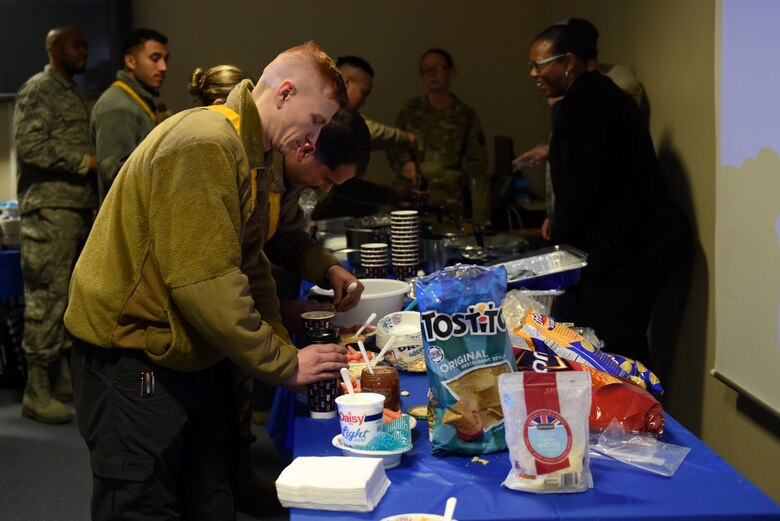 A Liberty Wing Airman prepares a bowl of chili at the Mid-Shift Chili Fest at Royal Air Force Lakenheath, England, Dec. 5, 2019. The Chili Fest was the first of iteration hosted by the RAF Lakenheath Community Action Team and consisted of a variety of chili, cookies, apple cider, an array of games, and merchandise from different organizations. (U.S. Air Force photo by Airman 1st Class Rhonda Smith)
