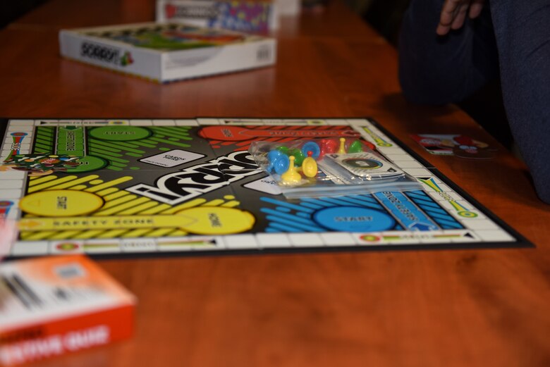 A volunteer sets up activities at the first ever Mid-Shift Chili Fest at Royal Air Force Lakenheath, England, Dec. 5, 2019. The Chili Fest was the first of iteration hosted by the RAF Lakenheath Community Action Team and consisted of a variety of chili, cookies, apple cider, an array of games, and merchandise from different organizations. (U.S. Air Force photo by Airman 1st Class Rhonda Smith)
