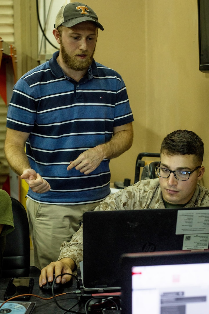 An engineering instructor provides a U.S. Marine with Combat Logistics Battalion (CLB) 24, attached to Special Purpose Marine Air Ground Task Force-Crisis Response-Central Command, with guidance during 3D print training in Kuwait, Aug. 28, 2019. A Marine Air Ground Task Force is specifically designed to be capable of deploying aviation, ground, and logistics forces forward at a moment’s notice.  (U.S. Marine Corps photo by Sgt. David Bickel)