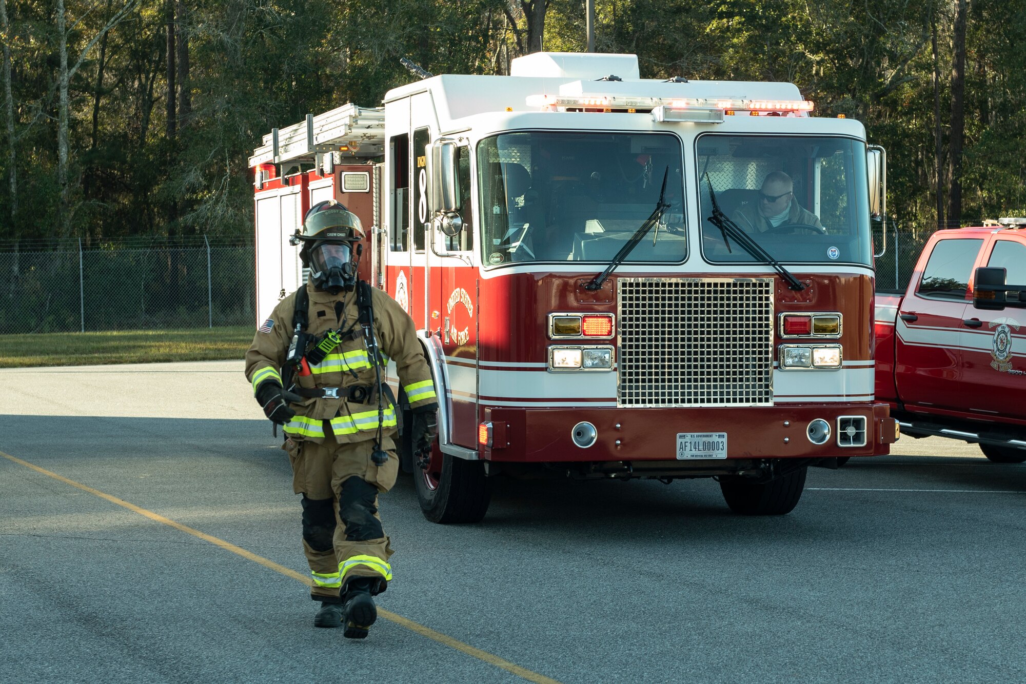 A photo of an Airman and the fire department arriving on scene during an evacuation drill.