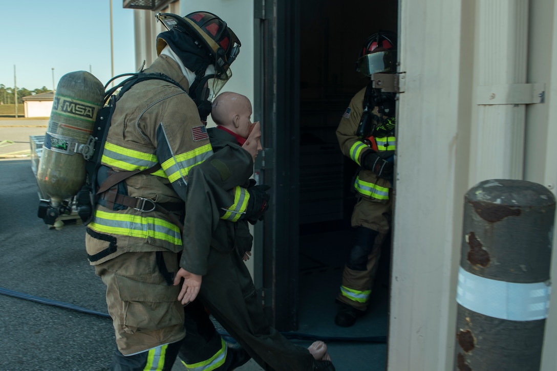 A photo of an Airman recovering a simulated survivor during an evacuation drill.
