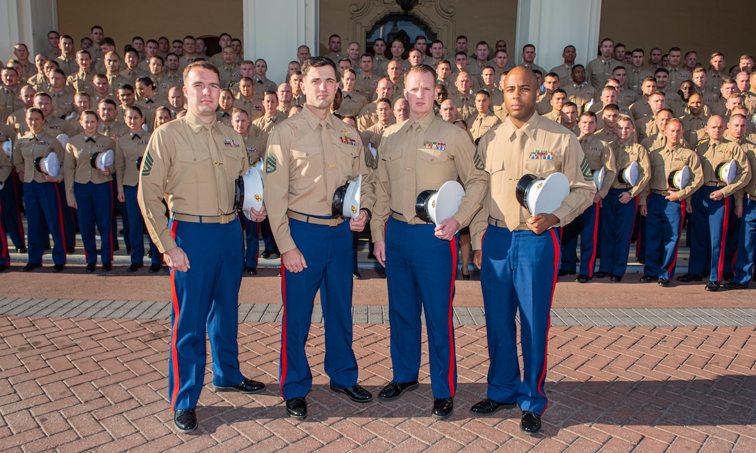 Four enlisted Marines, part of the newest cadre of NCOs attending the Naval Postgraduate School, join Marine Corps officers on the front steps of Herrmann Hall, Nov. 11.