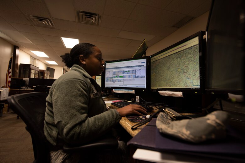 A photo of an Airman checking forecasts and flight routes