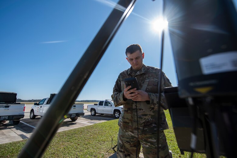 A photo of an Airman looking at forecast readings.