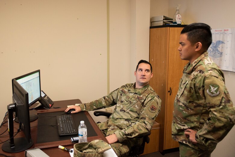 A photo of Airmen reviewing weather information
