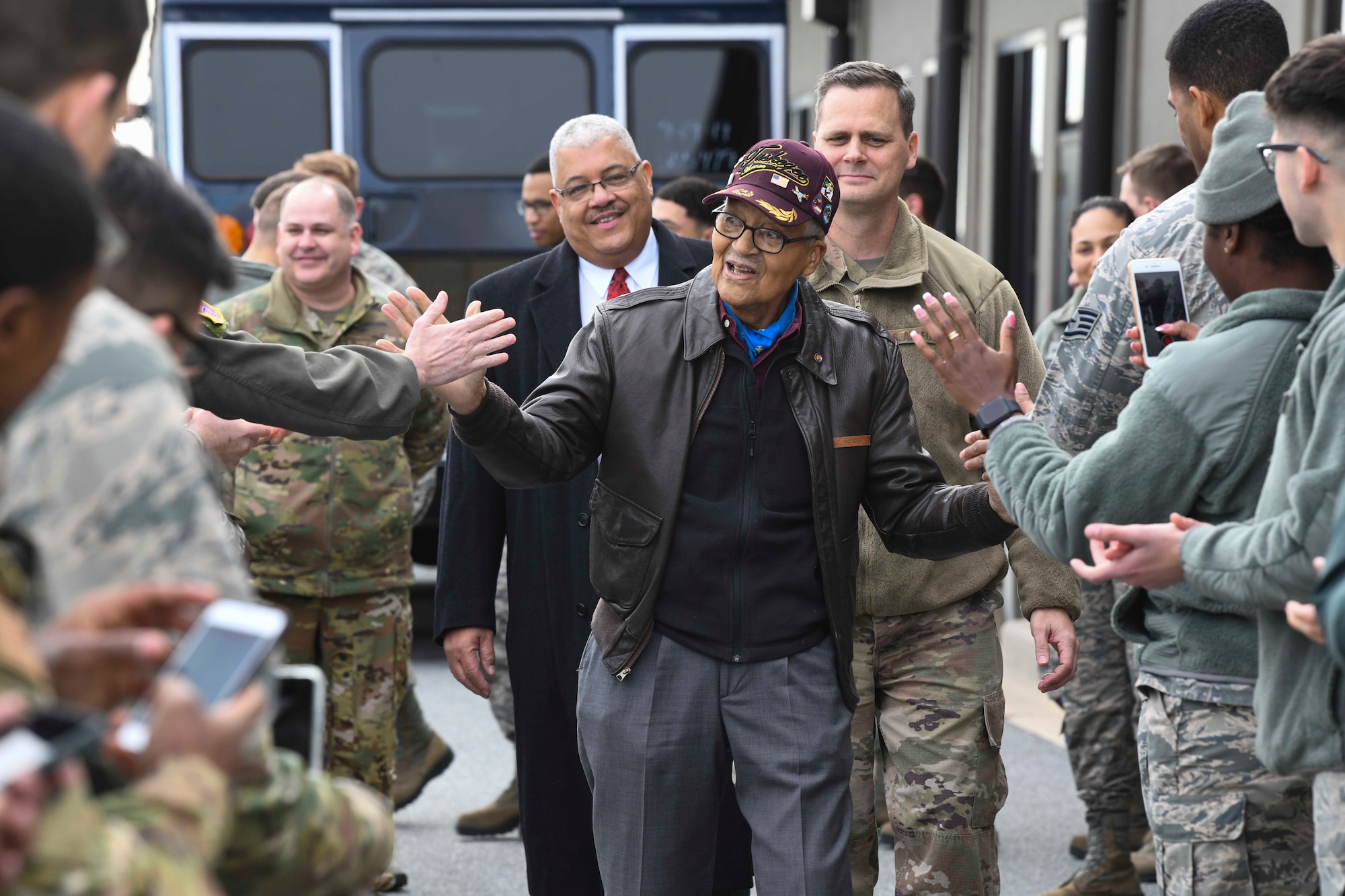 Former Tuskegee Airman, retired Col. Charles McGee, high-fives Airmen during his visit Dec. 6, 2019, at Dover Air Force Base, Del. He served a total of 30 years in the U.S. Air Force, beginning with the U.S. Army Air Corps, and flew a total of 409 combat missions in World War II, Korea and Vietnam. The Tuskegee program began in 1941 when the 99th Pursuit Squadron was established, and its Airmen were the first ever African-American military aviators in the U.S. Army Air Corps. (U.S. Air Force photo by Senior Airman Christopher Quail)