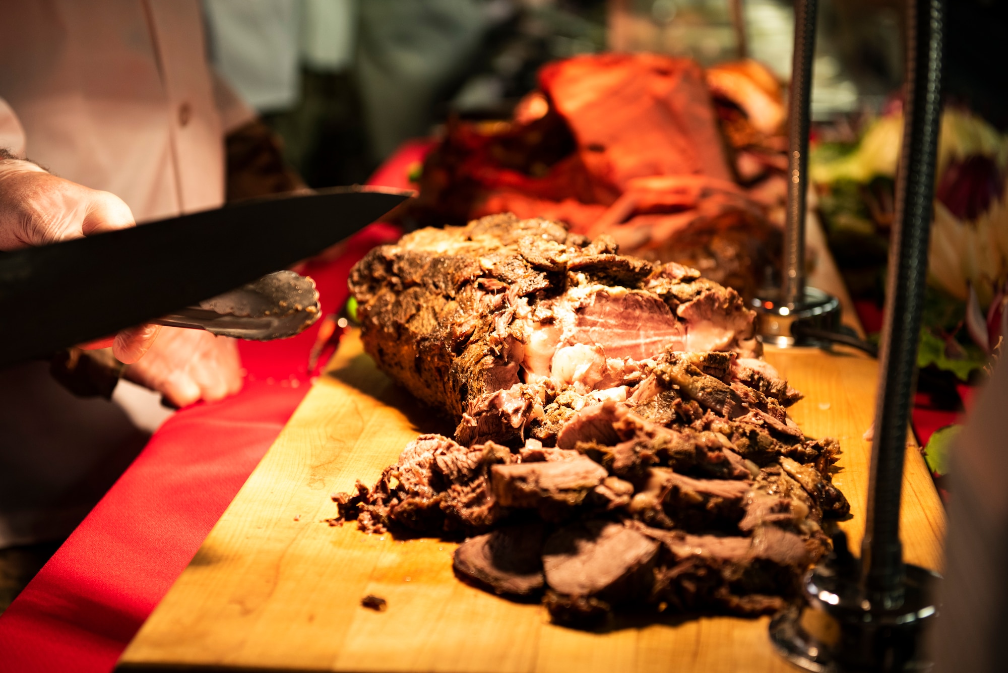 A slab of roast beef is carved at the 325th Force Support Squadron holiday meal at Tyndall Air Force Base, Florida, Nov. 28, 2019. Meal attendees were served by commanders, chiefs, first sergeants, and special guests of the 325th Fighter Wing. (U.S. Air Force photo by Staff Sgt. Magen M. Reeves)