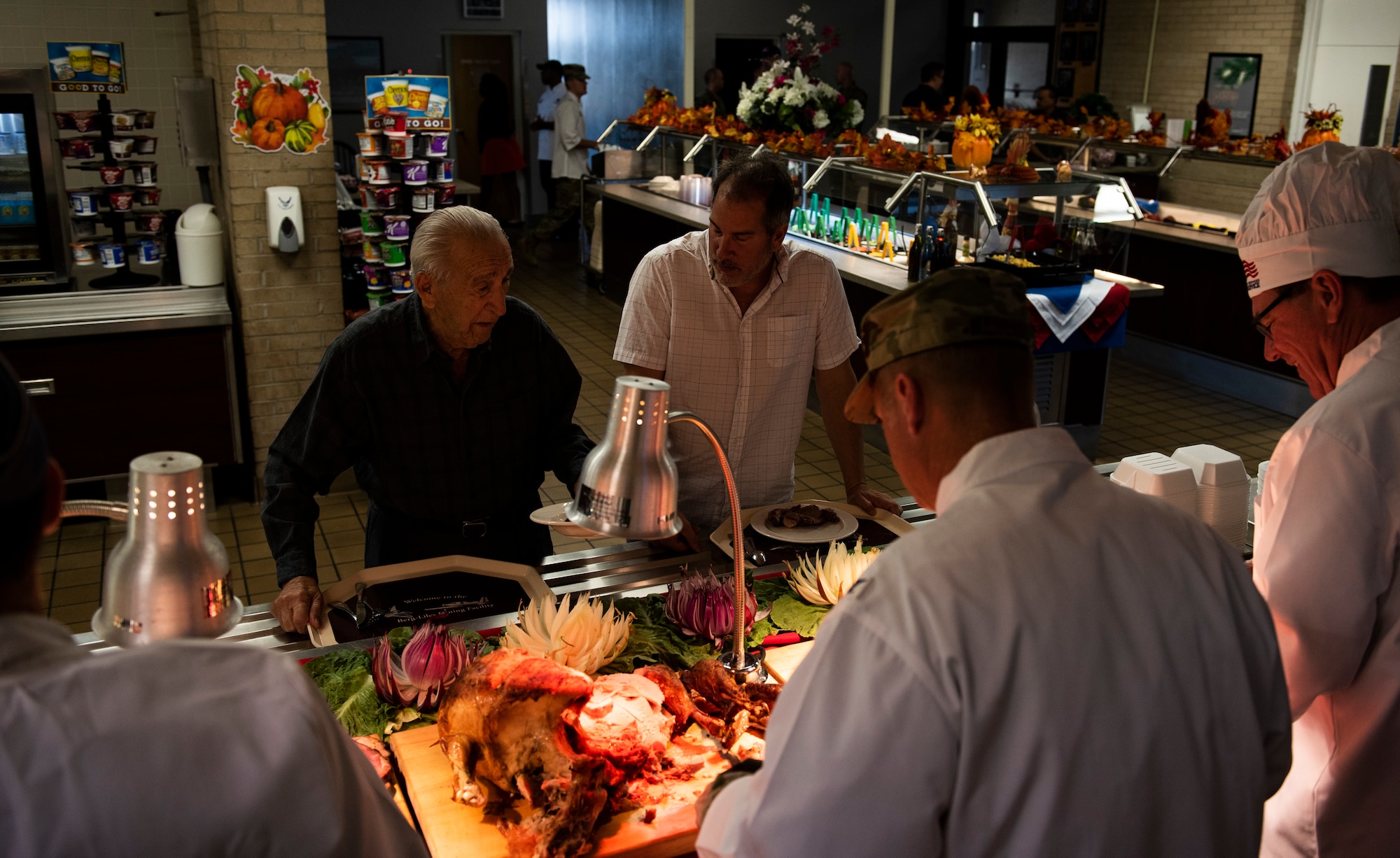 Retired U.S. Air Force Lt. Col. Daniel Daube, left, and his son, Dr. Daniel Daube, right, are served a Thanksgiving holiday meal at the 325th Force Support Squadron dining facility at Tyndall Air Force Base, Florida, Nov. 28, 2019. Commanders, chiefs, first sergeants, and special guests of 325th Fighter Wing units served food to those who wanted to attend the feast, including service members, their spouses, dependents and retirees. (U.S. Air Force photo by Staff Sgt. Magen M. Reeves)