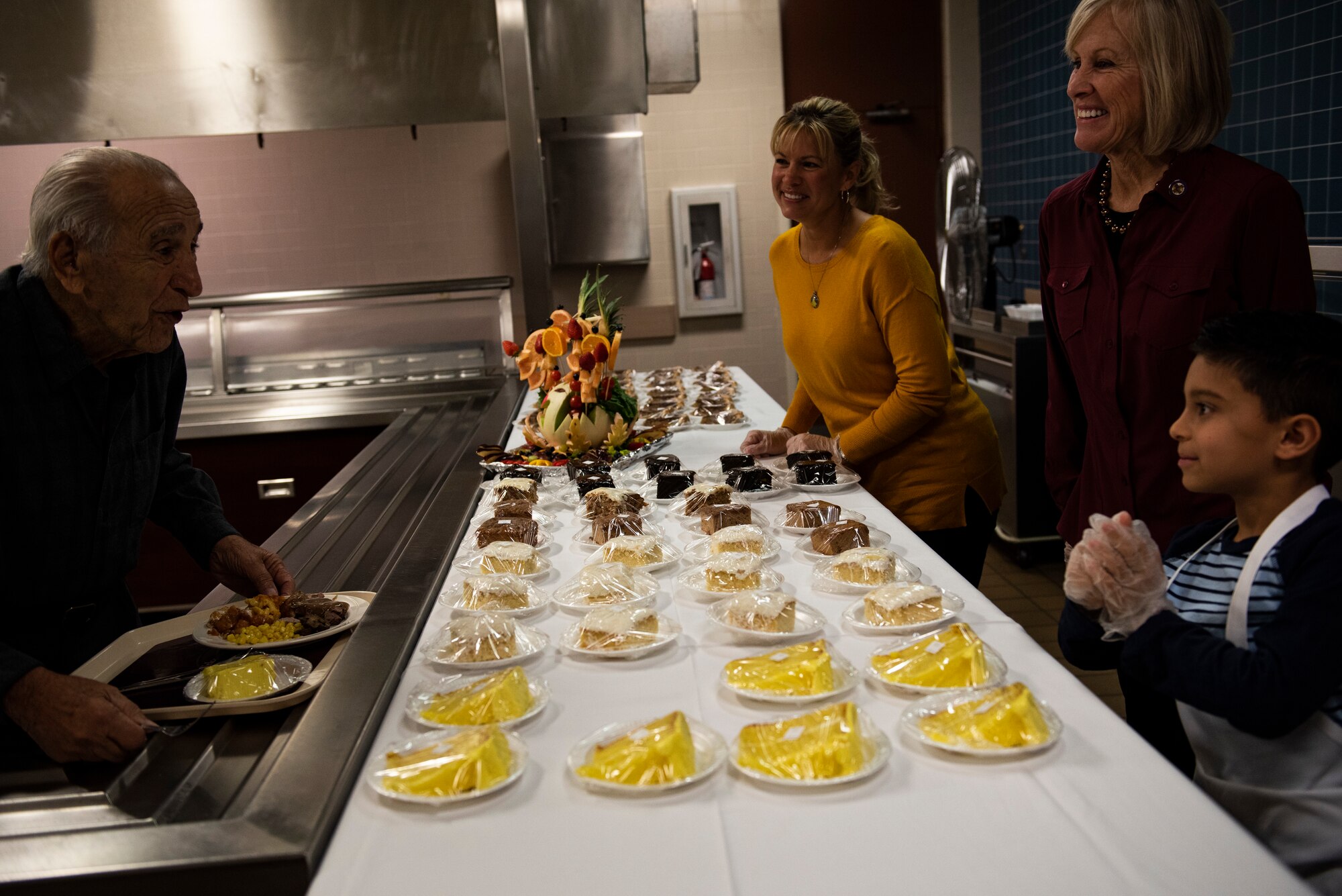 Retired U.S. Air Force Lt. Col. Daniel Daube, left, is served a dessert by Samantha Laidlaw, center, and Leah Dunn, right, at the 325th Force Support Squadron dining facility at Tyndall Air Force Base, Florida, Nov. 28, 2019. Attendees of the holiday meal celebration were served food by commanders, chiefs, first sergeants, and special guests of the 325th Fighter Wing. (U.S. Air Force photo by Staff Sgt. Magen M. Reeves)