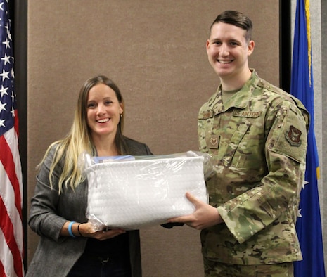 Rebecca Brooks, wife of Lt. Col. Brian Brooks, 718th Intelligence Squadron commander, presents a baby basket to Staff Sgt. Erskine, 718th IS, whose son was born Thanksgiving day. The 718th's Key Spouse program is currently focusing on deployed families and expecting families. Mrs. Rebecca Brooks, and three of the 718th IS members’ spouses have been dedicated in the Key Spouse program since September 2018.