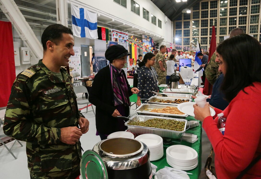 A military representative to U.S. Central Command’s (USCENTCOM) Coalition from Morocco serves native cuisine to guests at USCENTCOM’s 16th annual Coalition International Night in Hangar 5 at MacDill Air Force Base (AFB), Dec. 5, 2019. International Night started in December 2004 as a winter holiday party for the Coalition members and families. This year, members of 37 coalition countries displayed native customs and offered a taste of their traditional cuisines to over 1,700 guests. (U.S. Central Command Public Affairs photo by Tom Gagnier)