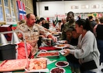 A military representative to U.S. Central Command’s (USCENTCOM) Coalition from Italy serves native cuisine to guests at USCENTCOM’s 16th annual Coalition International Night in Hangar 5 at MacDill Air Force Base (AFB), Dec. 5, 2019. International Night started in December 2004 as a winter holiday party for the Coalition members and families. This year, members of 37 coalition countries displayed native customs and offered a taste of their traditional cuisines to over 1,700 guests. (U.S. Central Command Public Affairs photo by Tom Gagnier)
