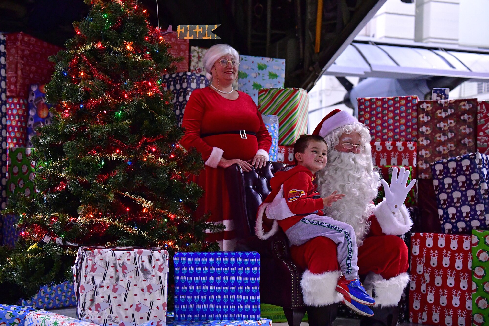 Children take photos with Mr. and Mrs. Claus during the Red-Nosed Herk holiday celebration.