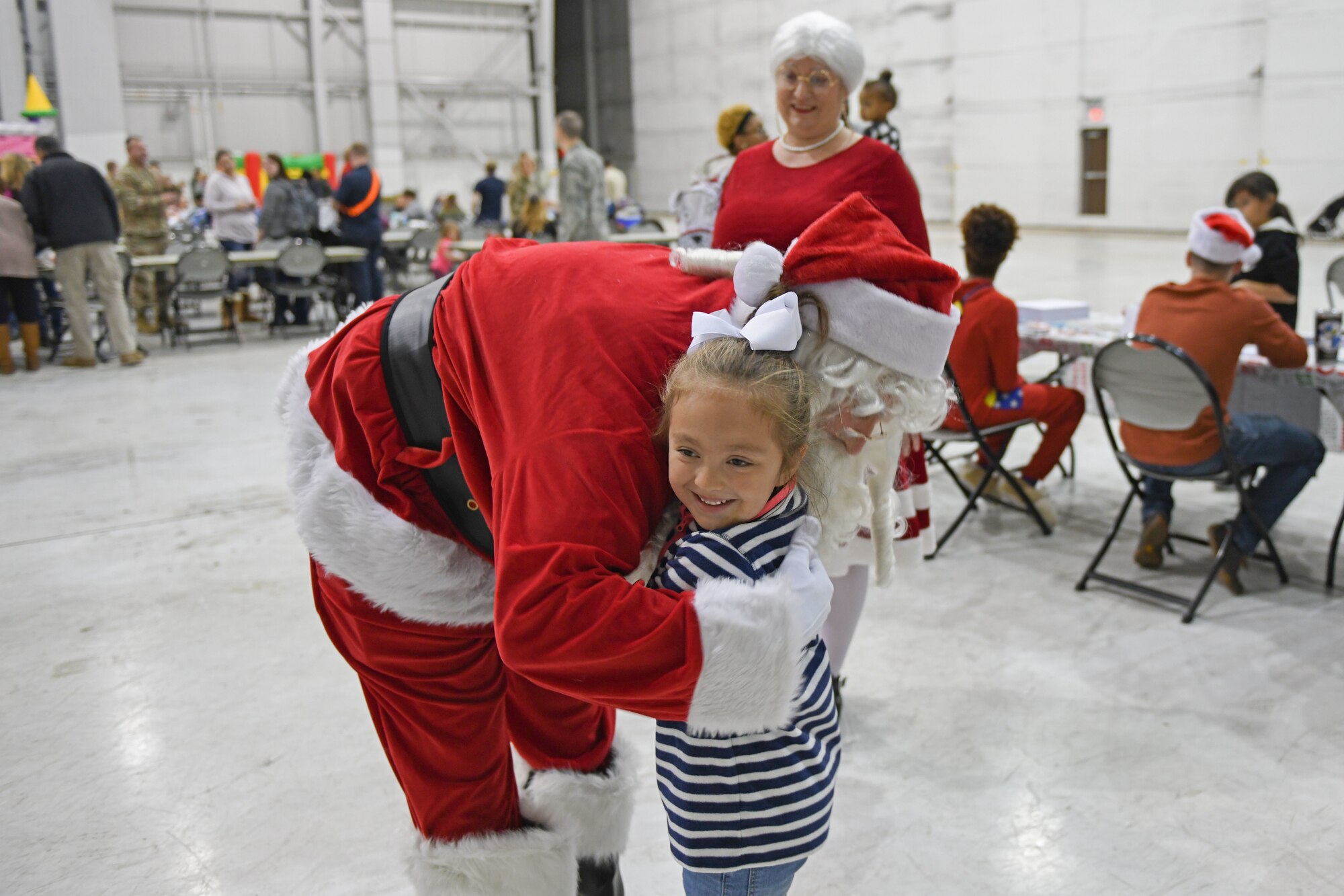 A child hugs Santa during the Red-Nosed Herk holiday celebration.