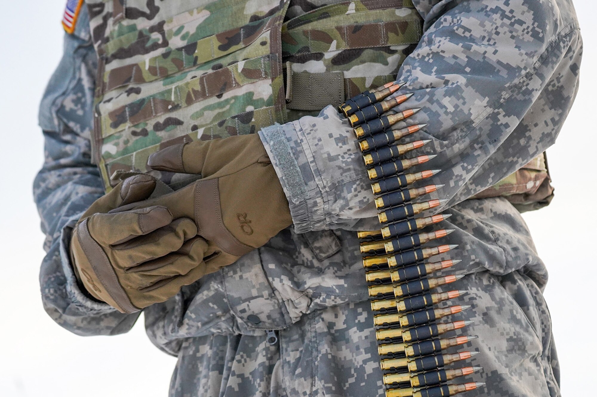 A paratrooper assigned to the 2nd Battalion, 377th Parachute Field Artillery Regiment, 4th Infantry Brigade Combat Team (Airborne), 25th Infantry Division, U.S. Army Alaska, holds a linked belt of 7.62mm ammunition before conducting live-fire qualification at Grezelka range, on Joint Base Elmendorf-Richardson, Alaska, Dec. 5, 2019. The Soldiers practiced identifying, and engaging targets at varying distances to solidify their proficiency with the weapons in sub-arctic conditions.