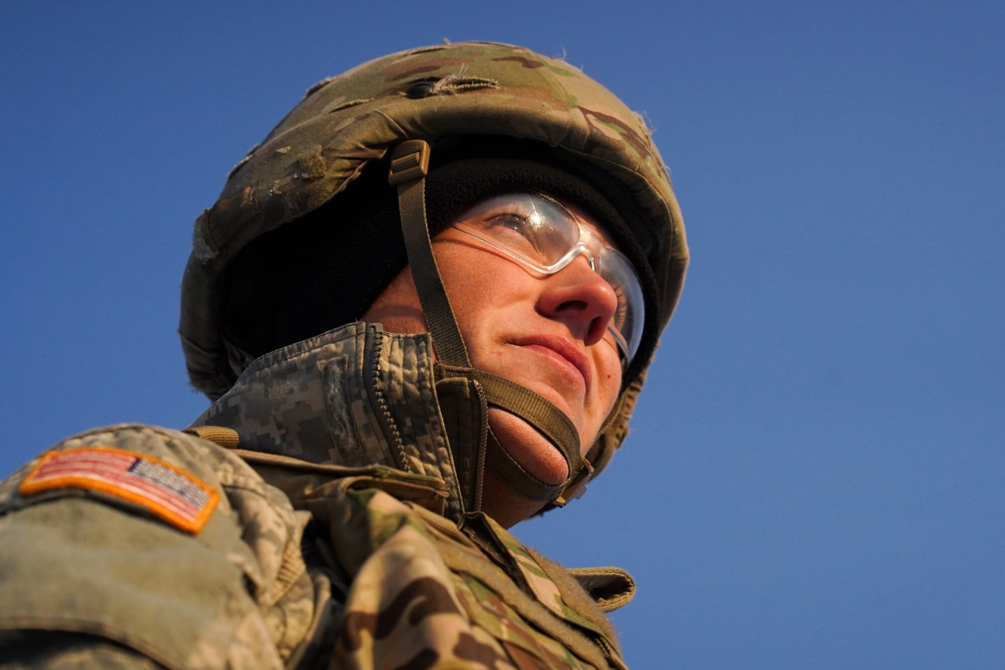 Army Pfc. Blade Briscoe, a native of Fort Drum, N.Y., a paratrooper assigned to the 2nd Battalion, 377th Parachute Field Artillery Regiment, 4th Infantry Brigade Combat Team (Airborne), 25th Infantry Division, U.S. Army Alaska, watches a fellow soldier fire an M240B machine gun while conducting live-fire qualification at Grezelka range, on Joint Base Elmendorf-Richardson, Alaska, Dec. 5, 2019. The Soldiers practiced identifying, and engaging targets at varying distances to solidify their proficiency with the weapons in sub-arctic conditions.