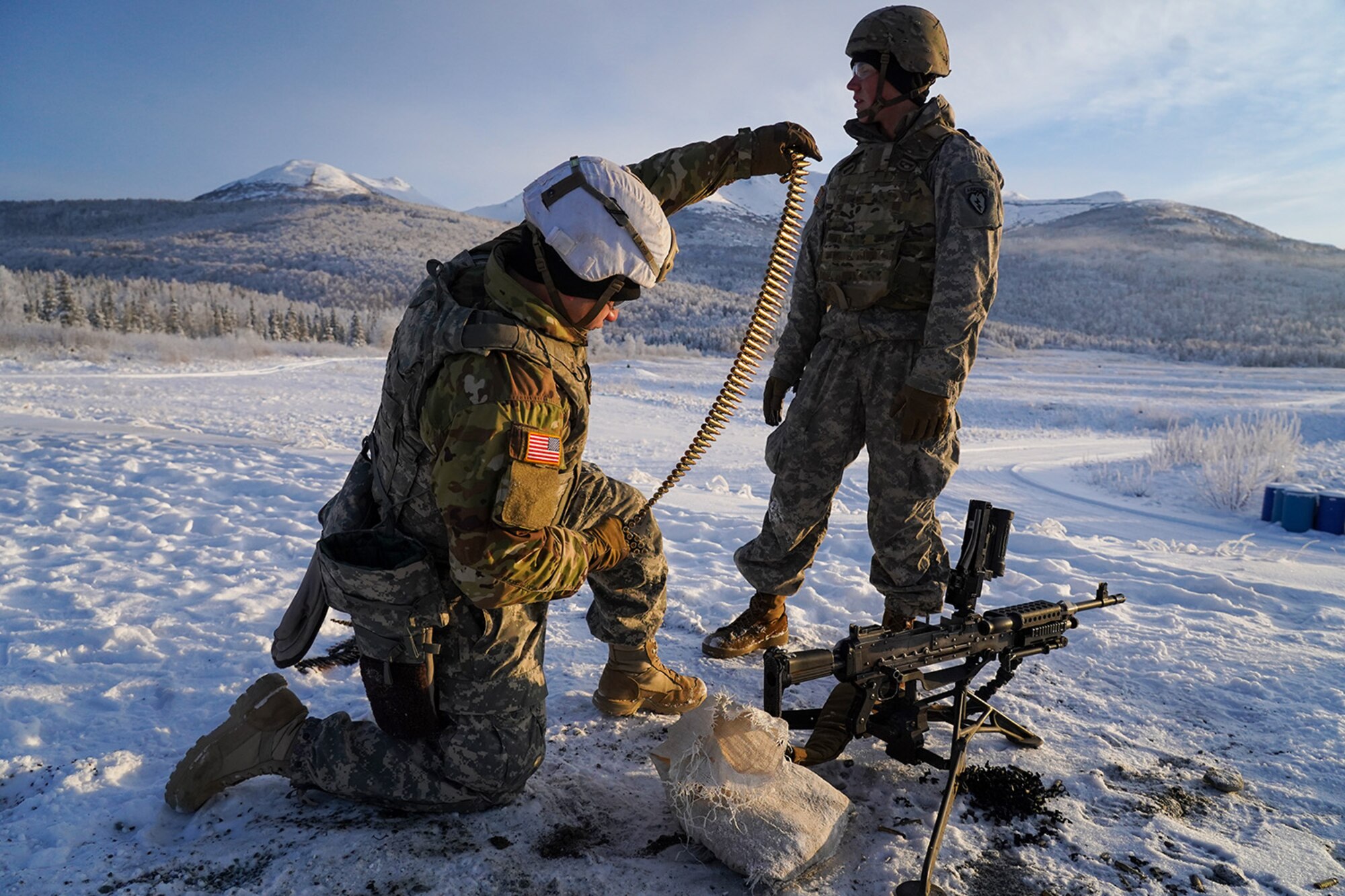 Army Pfc. John Paul Petrenko, a native of Jamaica, N.Y., left, and his assistant gunner Army Pfc. Blade Briscoe, a native of Fort Drum, N.Y., both paratroopers assigned to the 2nd Battalion, 377th Parachute Field Artillery Regiment, 4th Infantry Brigade Combat Team (Airborne), 25th Infantry Division, U.S. Army Alaska, prepare to load an M240B machine gun while conducting live-fire qualification at Grezelka range, on Joint Base Elmendorf-Richardson, Alaska, Dec. 5, 2019. The Soldiers practiced identifying, and engaging targets at varying distances to solidify their proficiency with the weapons in sub-arctic conditions.