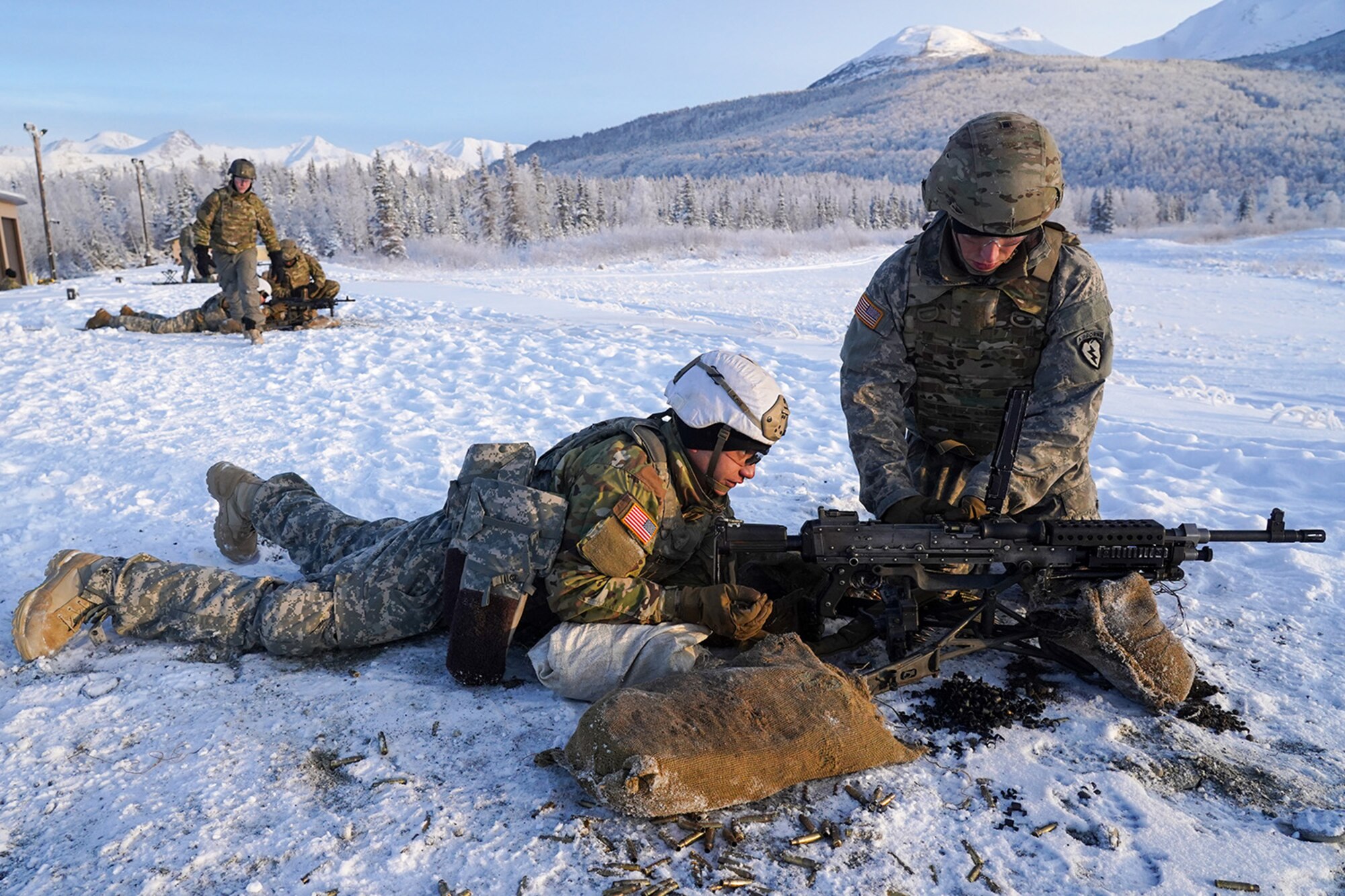 Army Pfc. John Paul Petrenko, a native of Jamaica, N.Y., left, and his assistant gunner Army Pfc. Blade Briscoe, a native of Fort Drum, N.Y., both paratroopers assigned to the 2nd Battalion, 377th Parachute Field Artillery Regiment, 4th Infantry Brigade Combat Team (Airborne), 25th Infantry Division, U.S. Army Alaska, load an M240B machine gun while conducting live-fire qualification at Grezelka range, on Joint Base Elmendorf-Richardson, Alaska, Dec. 5, 2019. The Soldiers practiced identifying, and engaging targets at varying distances to solidify their proficiency with the weapons in sub-arctic conditions.