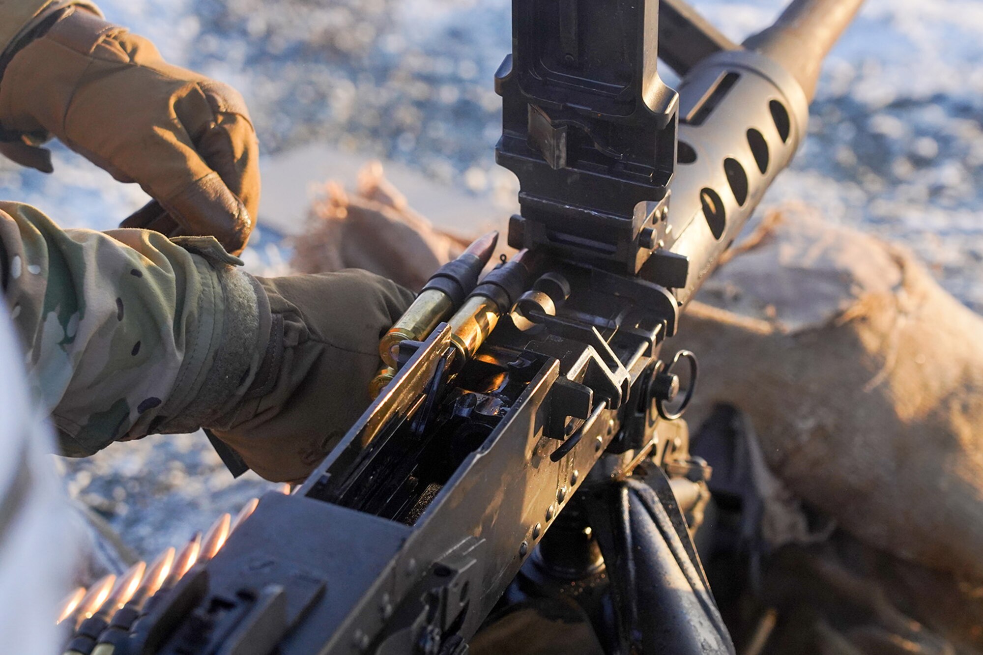A paratrooper assigned to the 2nd Battalion, 377th Parachute Field Artillery Regiment, 4th Infantry Brigade Combat Team (Airborne), 25th Infantry Division, U.S. Army Alaska, loads an M2 machine gun while conducting live-fire qualification at Grezelka range, on Joint Base Elmendorf-Richardson, Alaska, Dec. 5, 2019. The Soldiers practiced identifying, and engaging targets at varying distances to solidify their proficiency with the weapons in sub-arctic conditions.