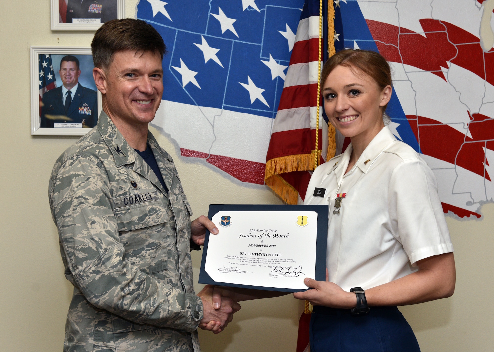 U.S. Air Force Col. Thomas Coakley, 17th Training Group commander, presents the 316th Training Squadron Student of the Month award to Spc. Kathryn Bell, 316th TRS student, at Brandenburg Hall on Goodfellow Air Force Base, Texas, Dec. 6, 2019. The 316th TRS’s mission is to conduct U.S. Air Force, U.S. Army, U.S. Marine Corps, U.S. Navy and U.S. Coast Guard cryptologic, human intelligence and military training. (U.S. Air Force photo by Airman 1st Class Robyn Hunsinger)