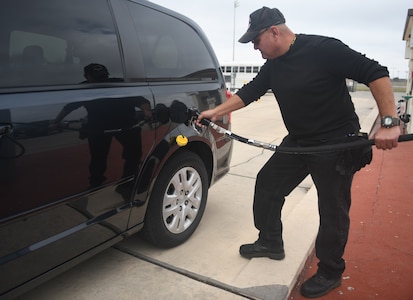 Gentleman pumping gas into a government vehicle.