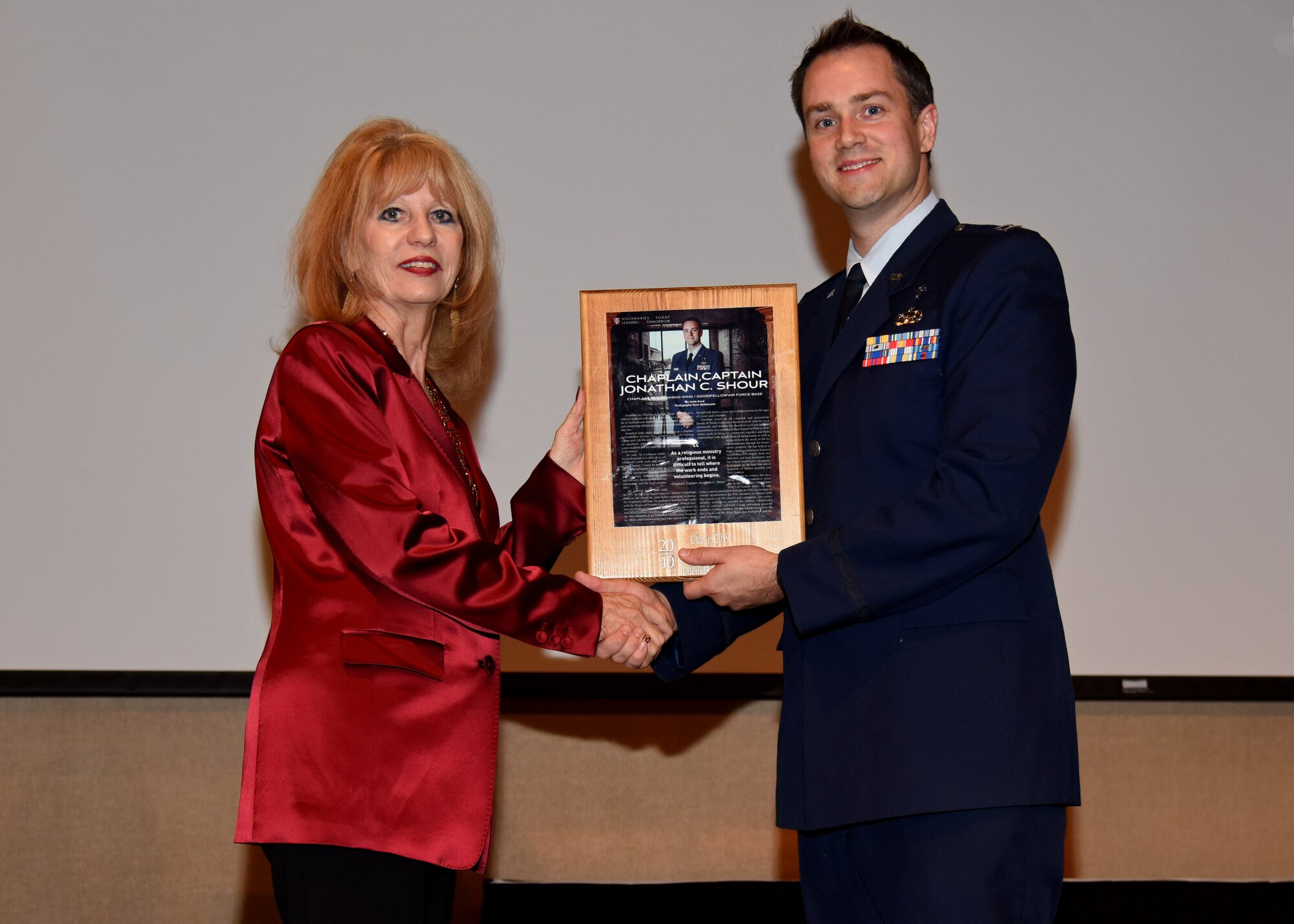 San Angelo Mayor Brenda Gunter presents U.S. Air Force Capt. Johnathan Shour, 17th Training Wing chaplain, with a plaque to congratulate him on being one of 20 selected nominees for 20 Under 40 San Angelo at the McNease Convention Center in San Angelo, Texas, December 5, 2019. The 20 selectees were from all walks of life including lawyers, doctors, and school teachers. (U.S. Air Force photo by Airman 1st Class Ethan Sherwood)