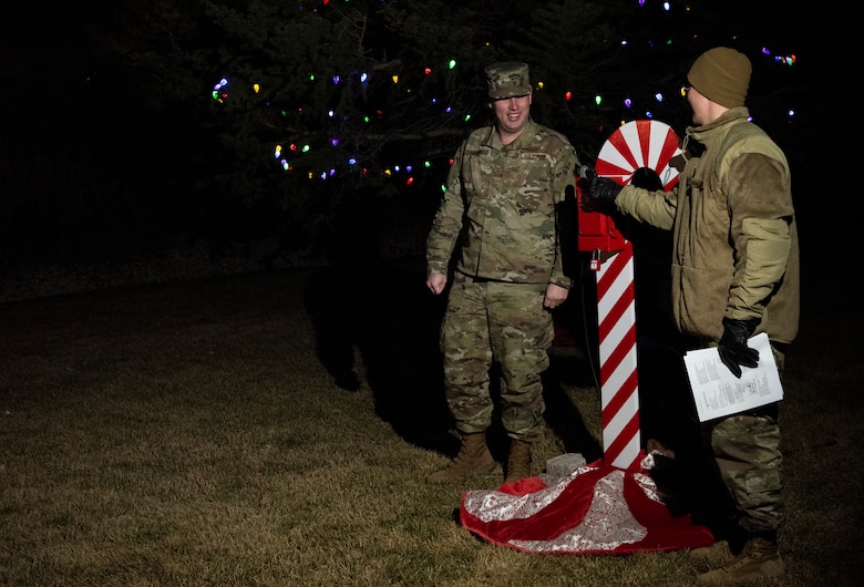 Airman 1st Class Joshua Martin, 50th Operations Support Squadron student, left, and Airman 1st Class John Carmichael, 50th OSS space systems operator, right, flip a switch during the tree lighting ceremony Dec. 5, 2019, at Schriever Air Force Base, Colorado. Dorm Airmen volunteered and were thanked for helping during their first holiday ceremony on an Air Force installation. (U.S. Air Force photo by Airman Amanda Lovelace)