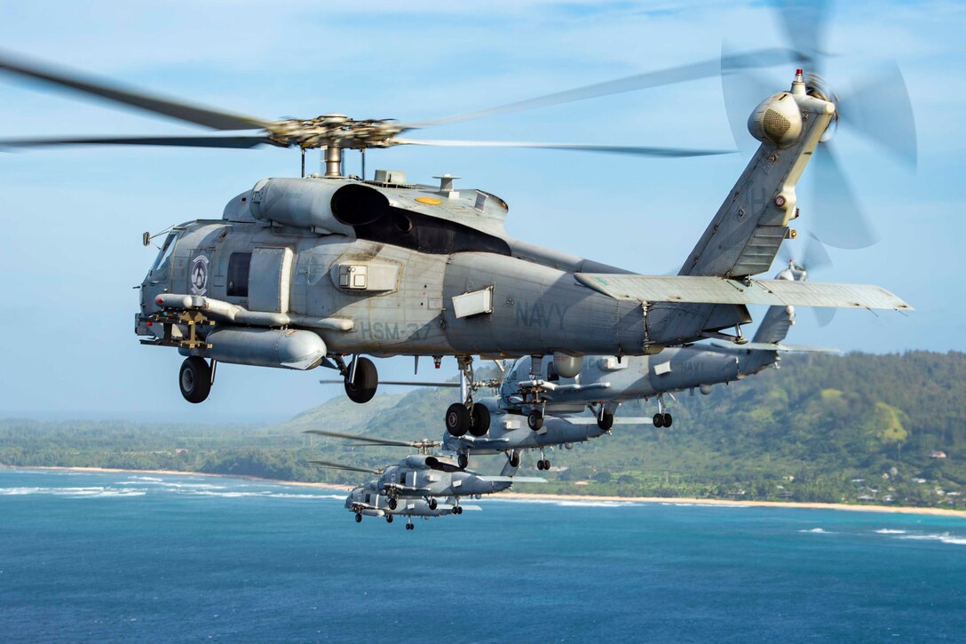 A group of helicopters fly in formation.