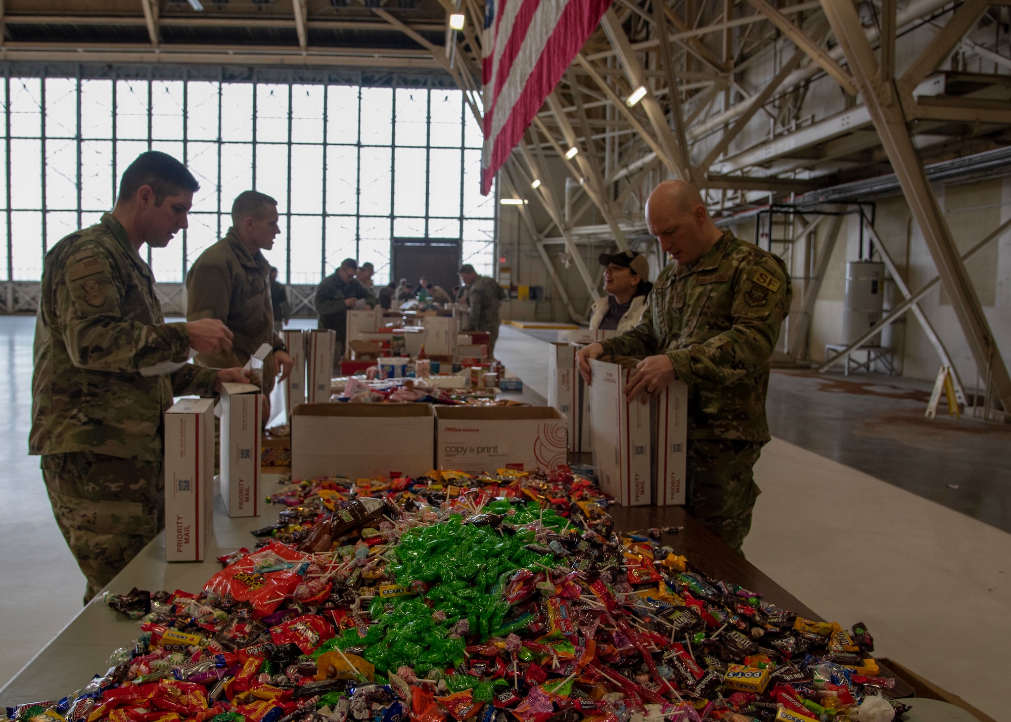 Active duty and civilian volunteers pack holiday care packages for overseas deployed troops at Fairchild Air Force Base, Washington, Dec. 3, 2019.