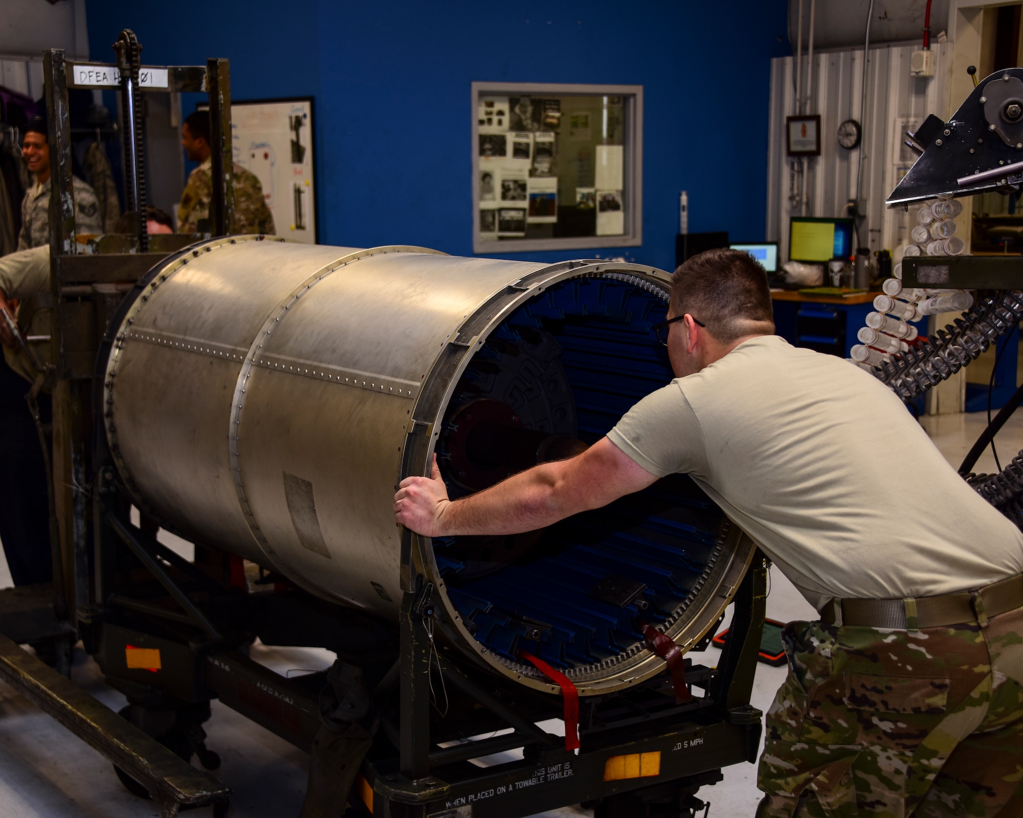 A photo of Airmen working on a Gatling gun
