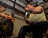A photo of Airmen working on a Gatling gun