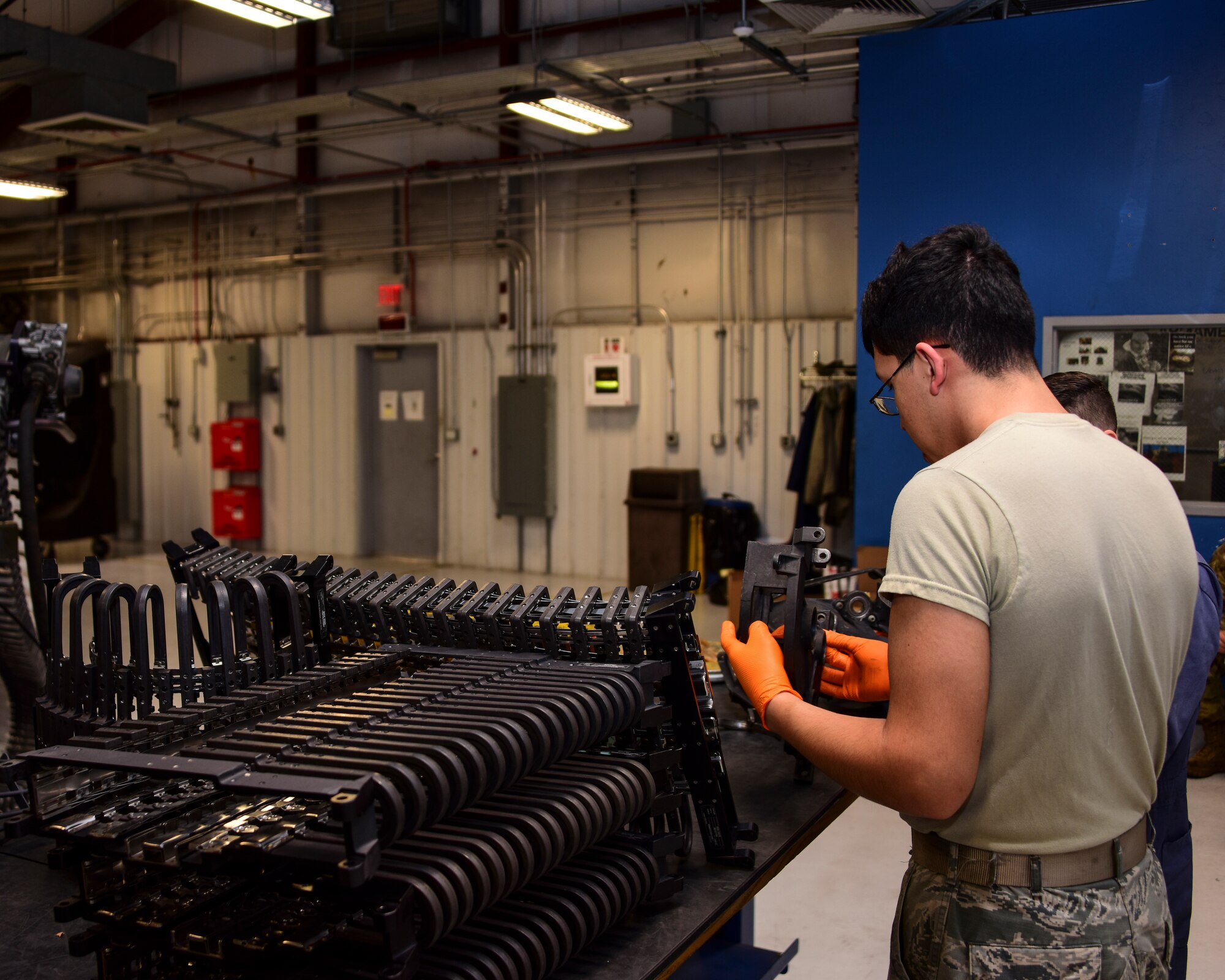 A photo of Airmen working on a Gatling gun