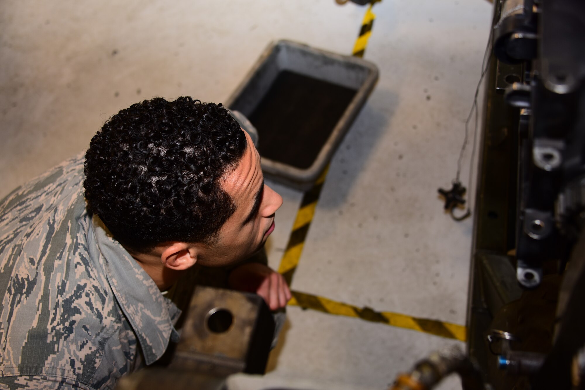 A photo of an Airman doing an inspection on a Gatling gun
