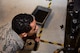 A photo of an Airman doing an inspection on a Gatling gun