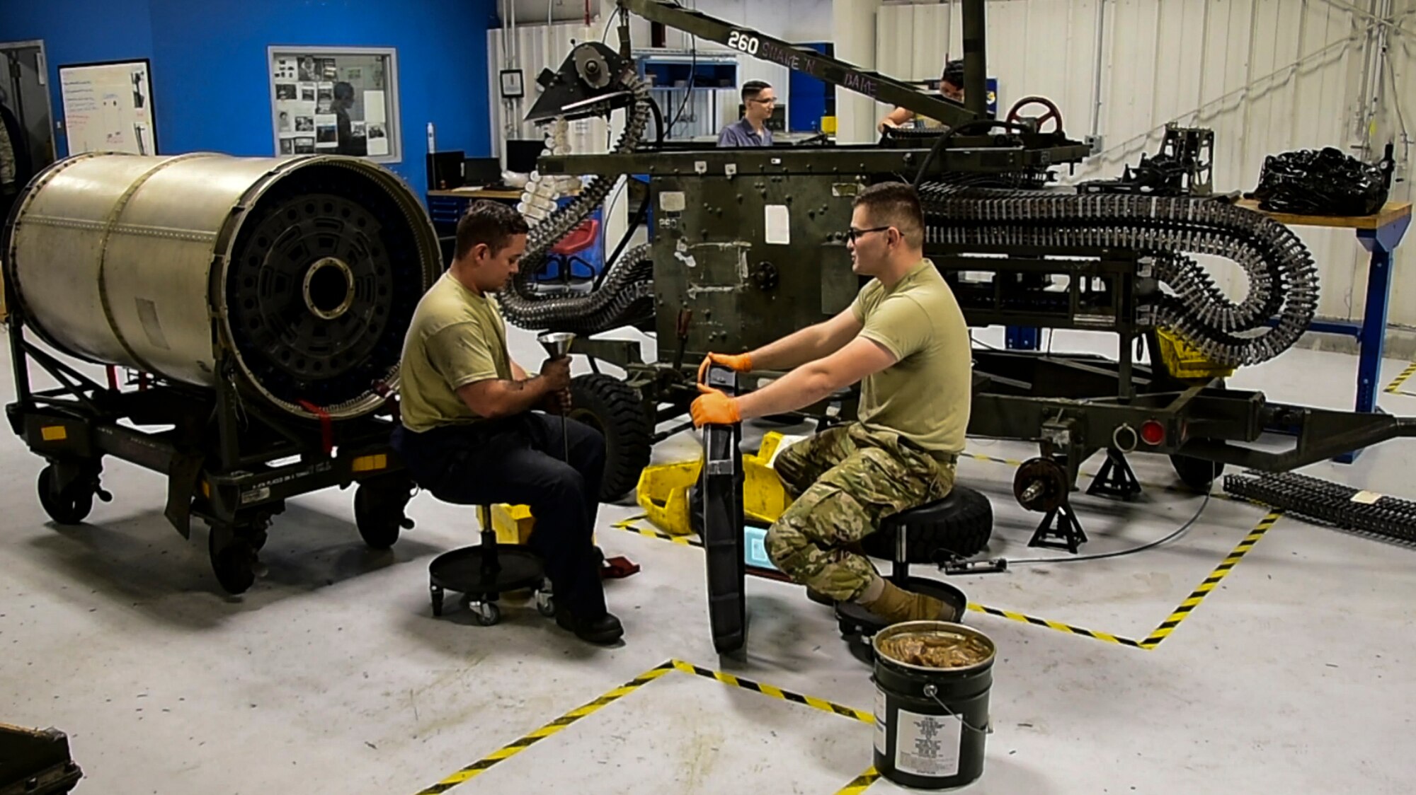 A photo of Airmen working on a Gatling gun