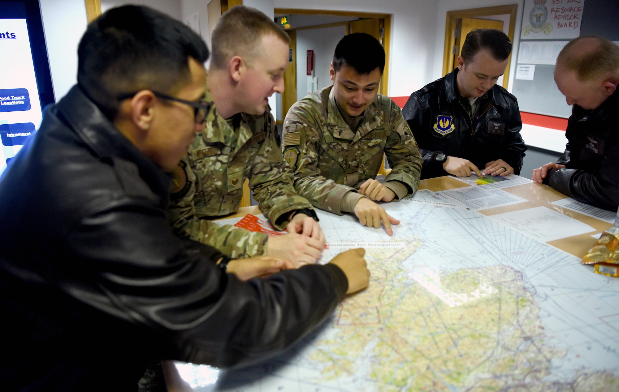 Airmen with the 100th Operations Support Squadron and 351st Air Refueling Squadron discuss potential combat crew communication practices during a briefing at RAF Mildenhall, England, Dec. 3, 2019. The combat crew communications shop’s main goal is to ensure the security of all aircrew communications during their flights. This includes training aircrew on the use of a variety of materials to help securely talk over the air. (U.S. Air Force photo by Senior Airman Brandon Esau)