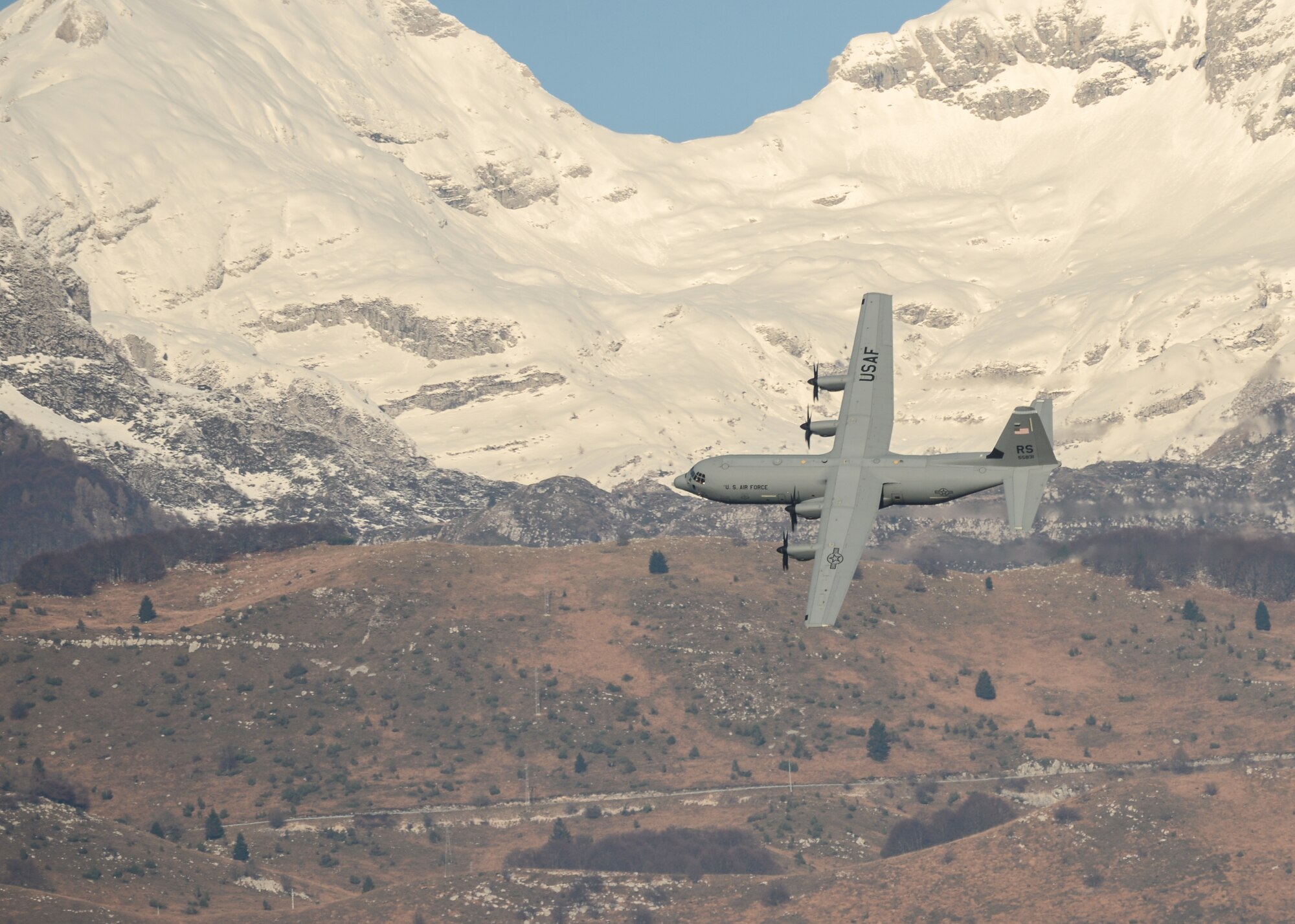 A C-130J Super Hercules flies across the Italian Dolomites