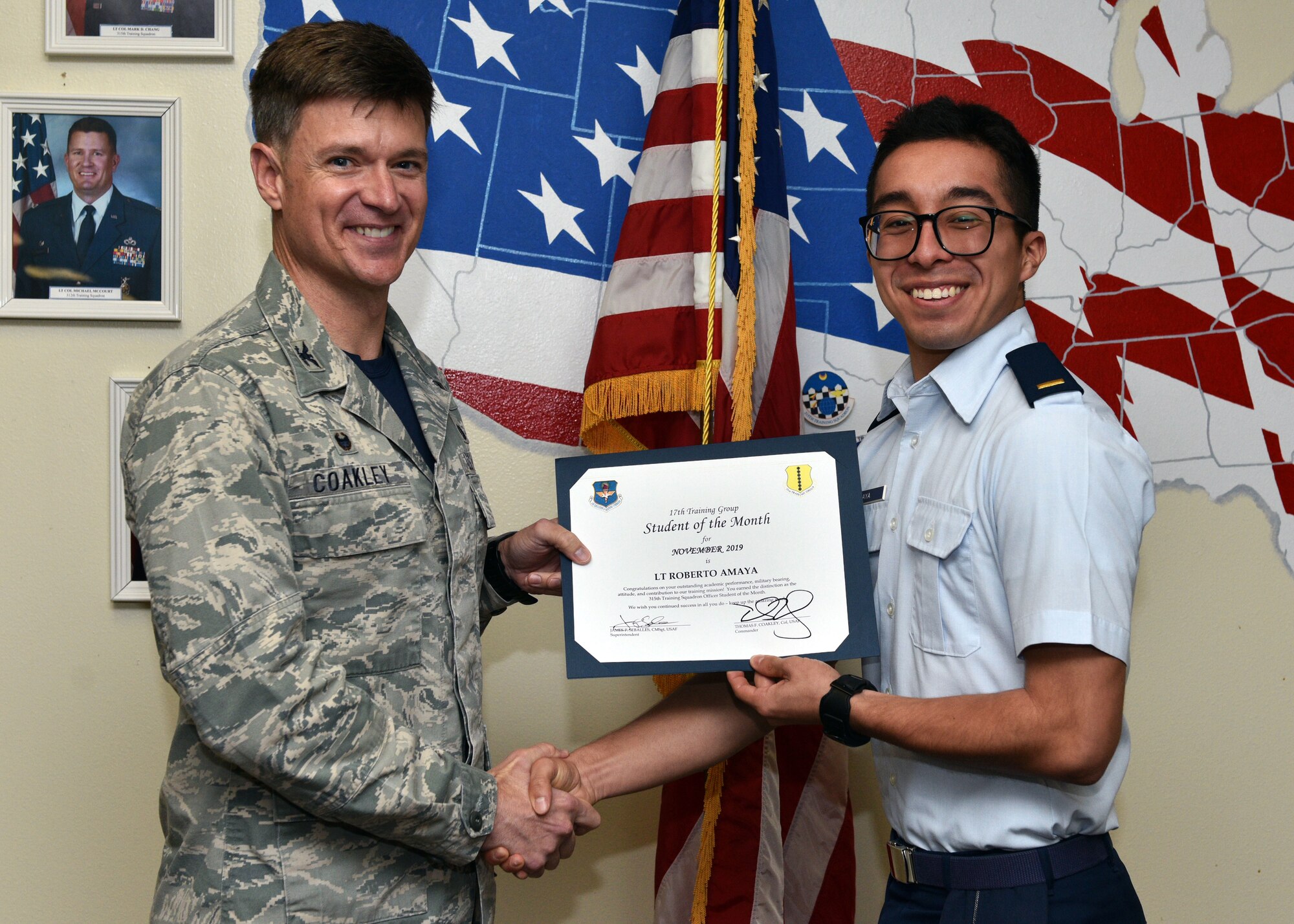U.S. Air Force Col. Thomas Coakley, 17th Training Group commander, presents the 315th Training Squadron Officer Student of the Month award to 2nd Lt. Roberto Amaya, 315th TRS student, at Brandenburg Hall on Goodfellow Air Force Base, Texas, Dec. 6, 2019. The 315th TRS’s vision is to develop combat-ready intelligence, surveillance and reconnaissance professionals and promote an innovative squadron culture and identity unmatched across the U.S. Air Force. (U.S. Air Force photo by Airman 1st Class Robyn Hunsinger/Released)