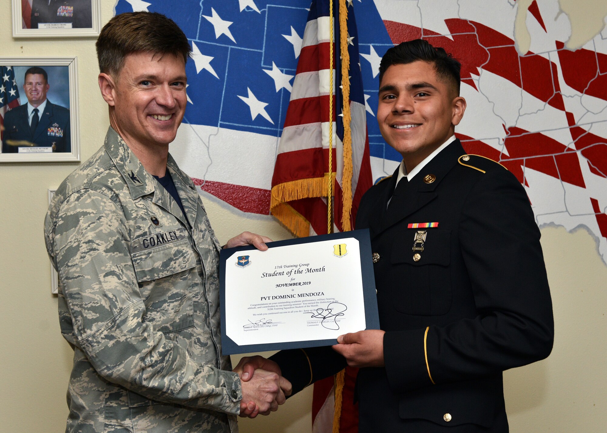 U.S. Air Force Col. Thomas Coakley, 17th Training Group commander, presents the 312th Training Squadron Student of the Month award to Pvt. Dominic Mendoza, 312th TRS student, at Brandenburg Hall on Goodfellow Air Force Base, Texas, Dec. 6, 2019. The 312th TRS’s mission is to provide Department of Defense and international customers with mission-ready fire protection and special instruments graduates and provide mission support for the Air Force Technical Applications Center. (U.S. Air Force photo by Airman 1st Class Robyn Hunsinger)