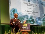Man speaks at podium during the 2019 Defense Manufacturing Conference Dec. 3