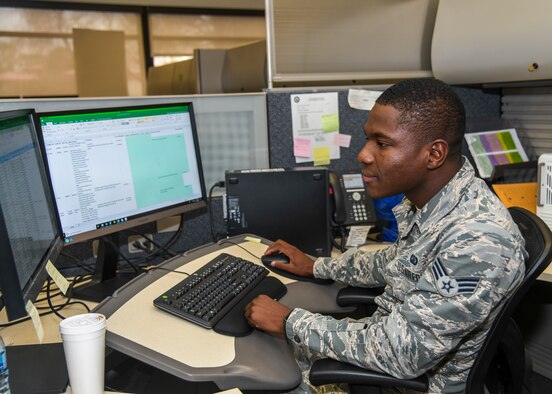 Senior Airman Prince Jarbo, 412th Comptroller Squadron, conducts checks on travel claims at his desk at Edwards Air Force Base, California, Dec. 4. (Air Force photo by Giancarlo Casem)