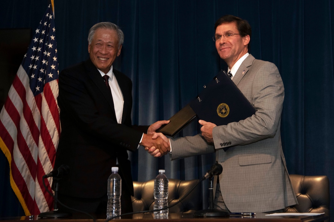 Defense Secretary Dr. Mark T. Esper shakes hands with another official.