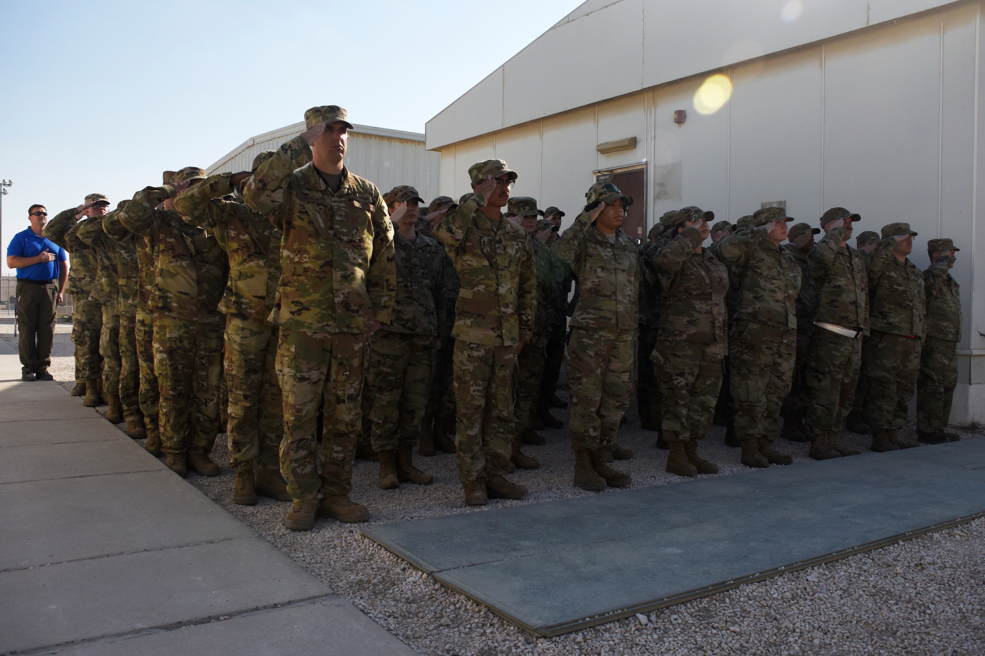 Airmen assigned to the 763rd Expeditionary Reconnaissance Squadron render a salute during the playing of the National Anthem during a ceremony held at Al Udeid Air Base, Qatar on Nov. 23, 2019. The 763 ERS held the ceremony in recognition of 29 years of continuous Rivet Joint operations in the U.S. Air Forces Central Command area of responsibility. (U.S. Air Force photo by Tech. Sgt. Ian Dean)