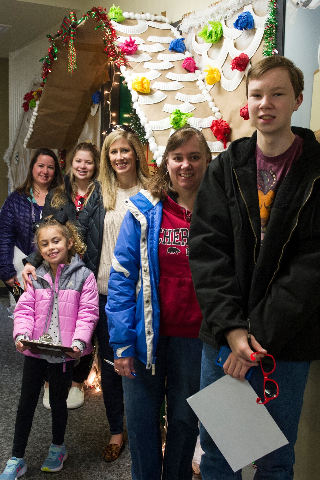 Members of Grissom’s Key Spouse program, and their children, pose for a picture under the gingerbread house constructed at the base finance office at Grissom Air Reserve Base, Ind., Dec. 8, 2019. Military and civilian personnel throughout the base decorated their office doors as part of a holiday-themed contest.
(U.S. Air Force photo/Staff Sgt. Courtney Dotson-Essett)