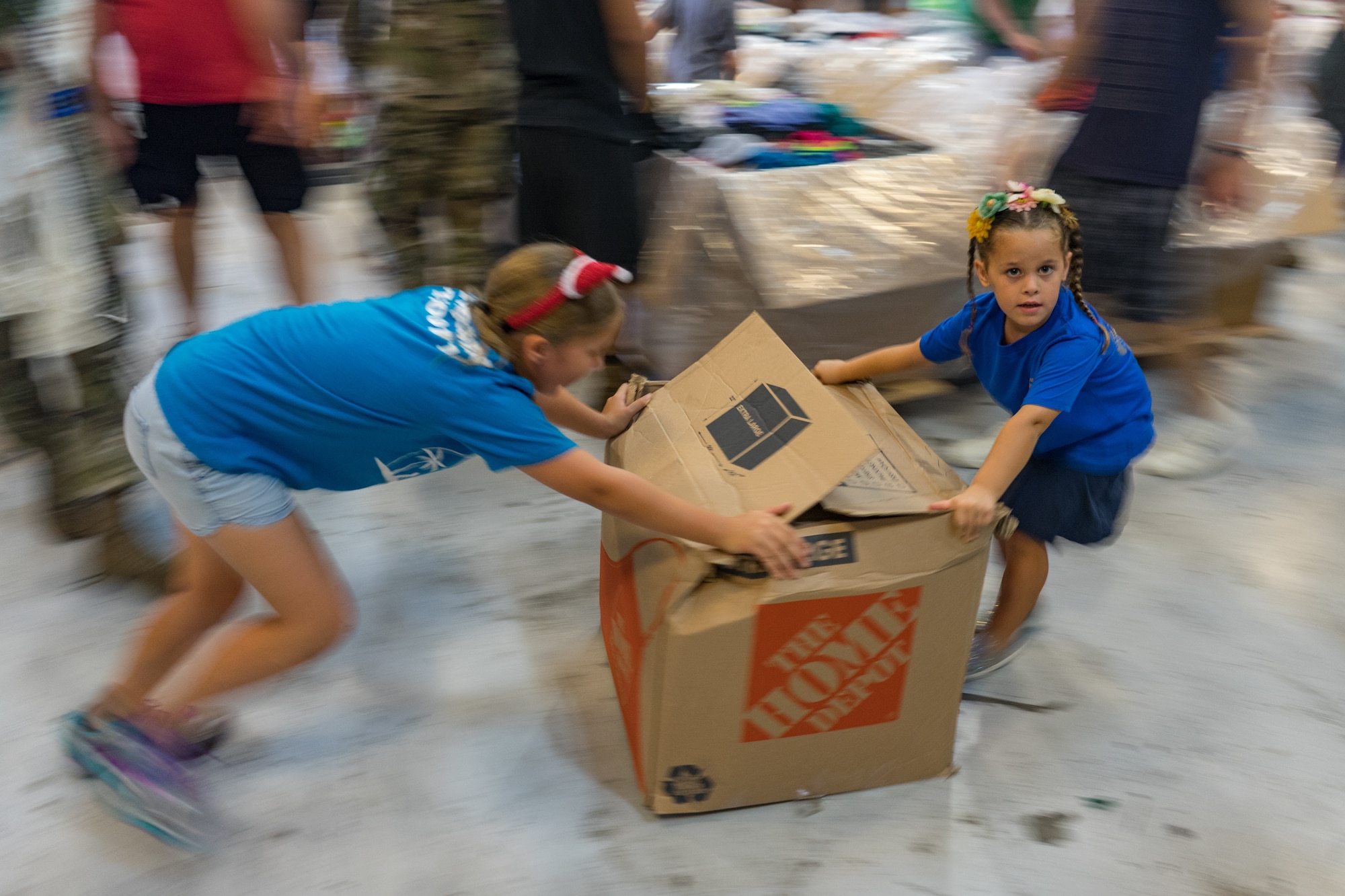 Volunteers slide a box of clothes