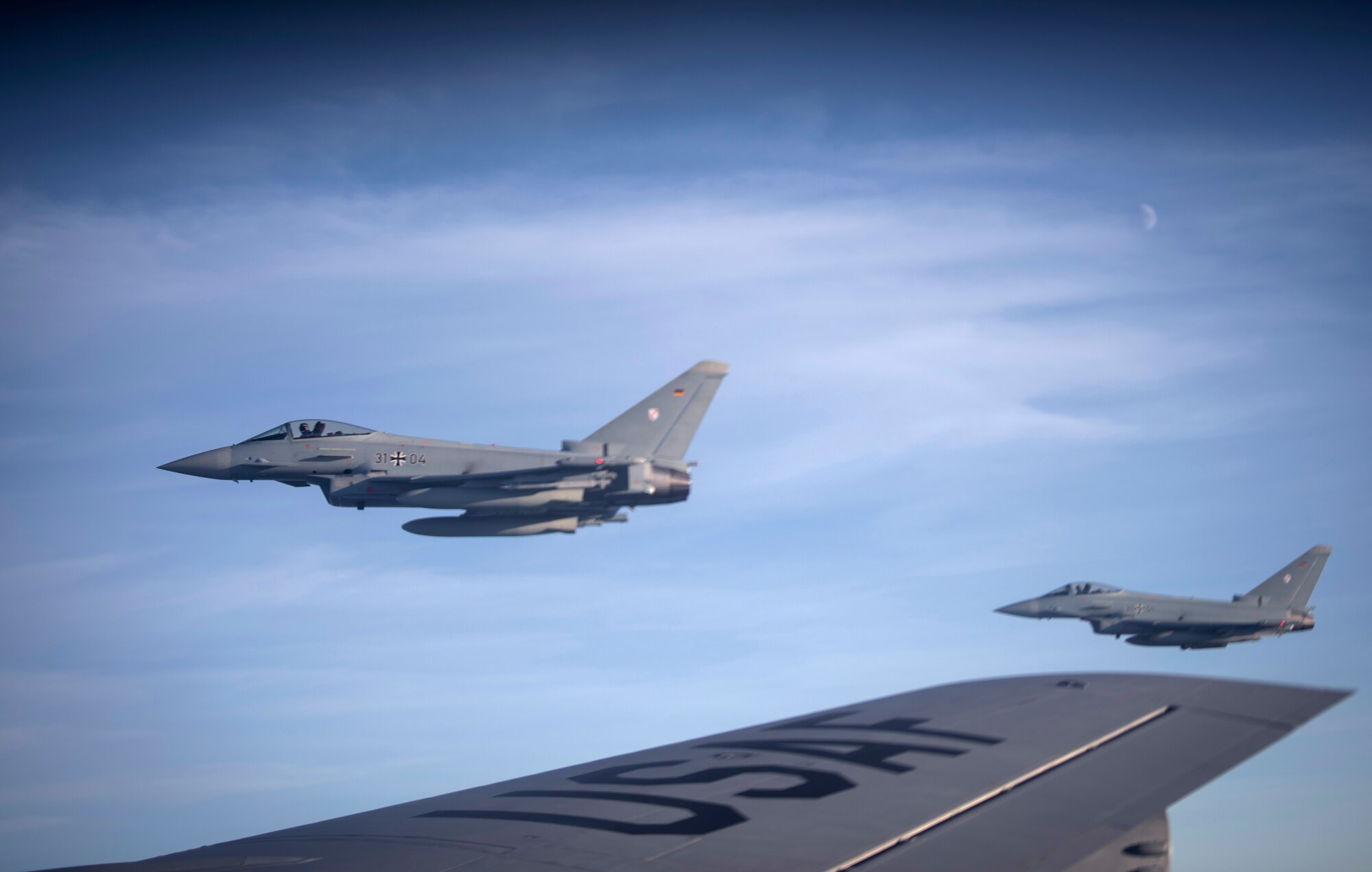 German air force Eurofighter Typhoons wait to receive fuel over Germany from a U.S. Air Force KC-135 Stratotanker from the 100th Air Refueling Wing, RAF Mildenhall, England, Dec 4, 2019. The Bloody Hundredth provides unrivaled air refueling support throughout Europe and Africa. (U.S. Air Force photo by Tech. Sgt. Emerson Nuñez)